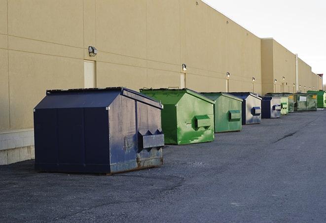 a fleet of red and blue construction dumpsters available for use in Apison, TN